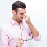 man experiencing eye pain and irritation showing symptoms of a corneal eye infection requiring emergency eye care